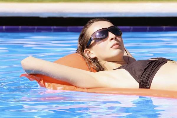 Mulher em um colchão de ar na piscina — Fotografia de Stock