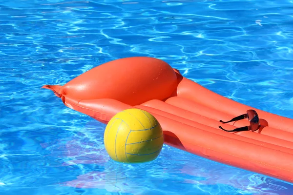 Воздушный матрас и волейбол в бассейне — стоковое фото
