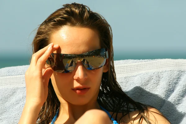 Woman in sunglasses in chaise — Stok fotoğraf