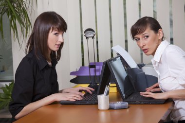 Two women gossip in office clipart