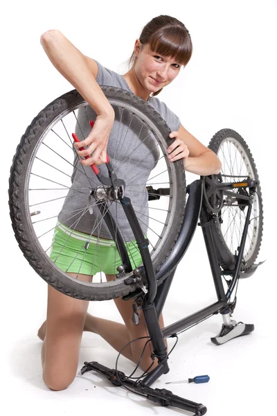 Woman repairs bicycle — Stock Photo, Image
