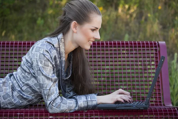 坐在板凳上的笔记本电脑的女人 — 图库照片