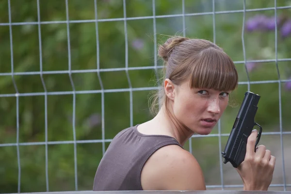 Kvinnlig agent med pistol dölja — Stockfoto