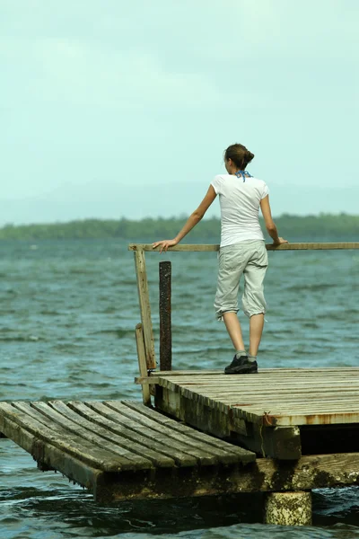 Vrouw stond op de houten pier — Stockfoto