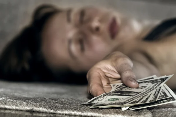 Женщина без сознания с деньгами — стоковое фото