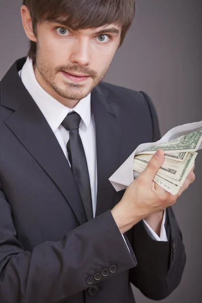 Бизнесмен с долларами в конверте — стоковое фото