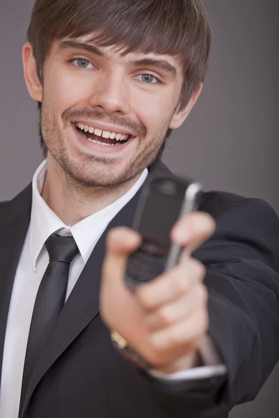 Riendo hombre de negocios mostrando el teléfono celular —  Fotos de Stock