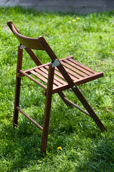 stock image Wooden camp chair on green grass