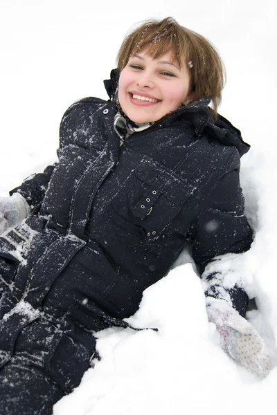 Sonriente chica tendida en la nieve — Foto de Stock