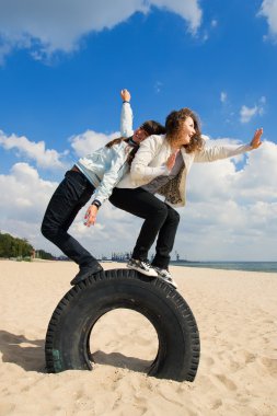 Two young girls having fun at the beach clipart