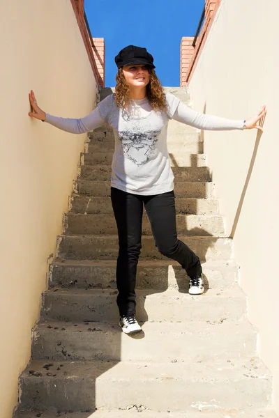 Cute young girl standing on the stairs — Stock Photo, Image
