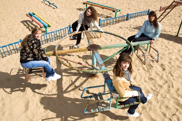 Meninas bonitas cavalgando alegre-go-round — Fotografia de Stock
