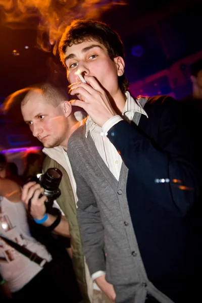 Young man smoking in the nightclub — Stock Photo, Image