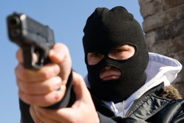 Criminal in mask aiming his target clipart