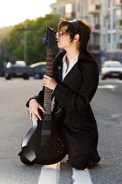 Krásná mladá brunetka líbání kytara — Stock fotografie