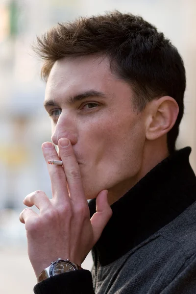 Mladý dospělý muž kouření — Stock fotografie