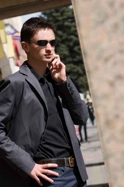 Cep telefonunu güneş gözlüğü görüşmelerde iş adamı — Stok fotoğraf