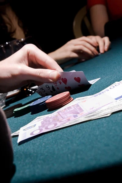 Игрок в покер проверяет свои карты — стоковое фото