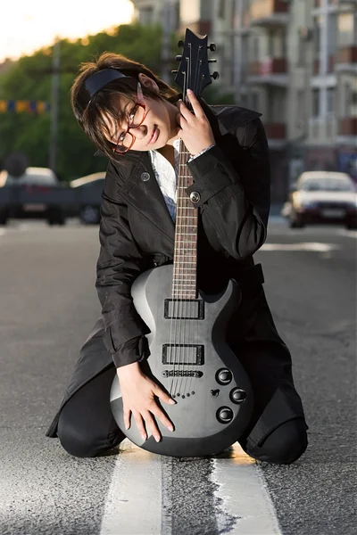 Sorrindo jovem morena segurando uma guitarra — Fotografia de Stock
