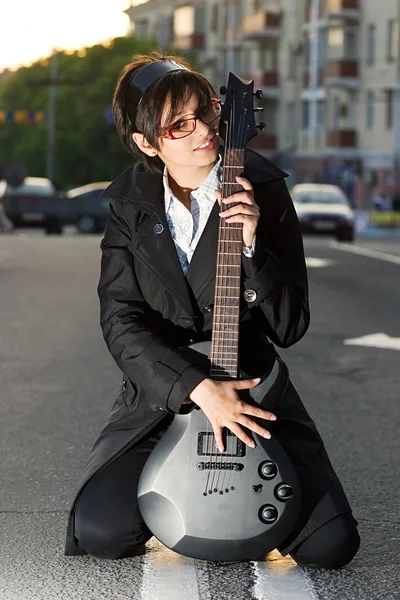 Sorrindo jovem morena com uma guitarra — Fotografia de Stock
