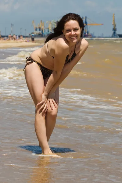 Молодая улыбающаяся брюнетка на берегу моря — стоковое фото