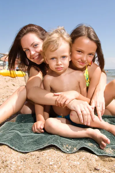Молода мама з дітьми на пляжі — стокове фото