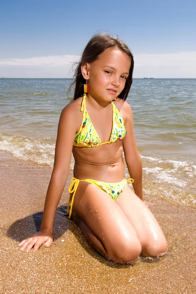 해변에 앉아 어린 소녀 — 스톡 사진