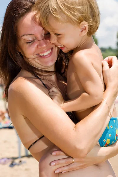 Jovem mãe abraçando seu pequeno filho — Fotografia de Stock