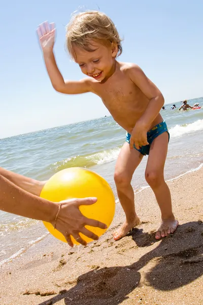 Küçük çocuk plas topu deniz kenarında — Stok fotoğraf