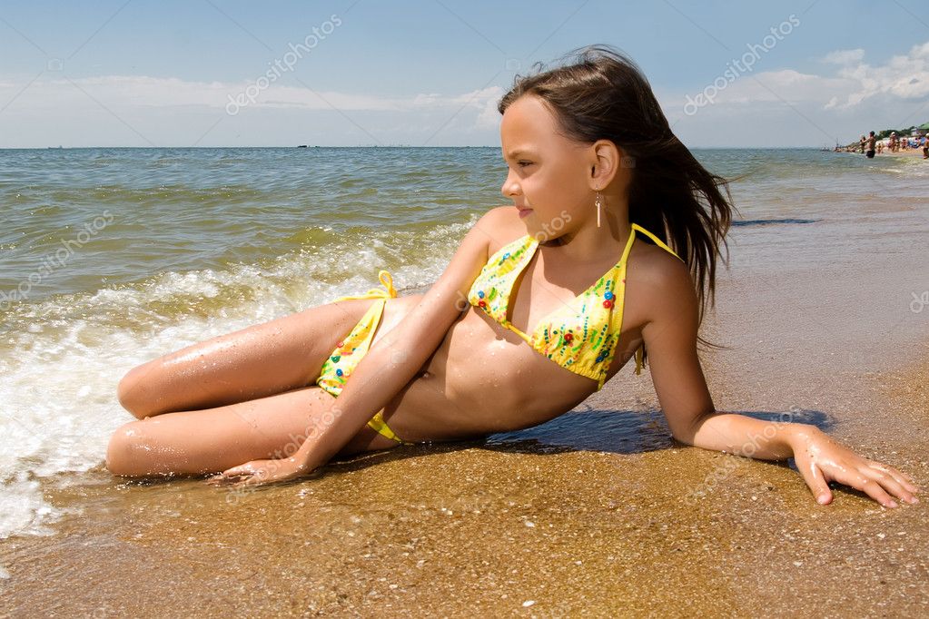 Little girl sunbathing at the beach Stock Photo by ©hurricanehank 3470161