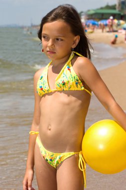 küçük kız sahilde bir top