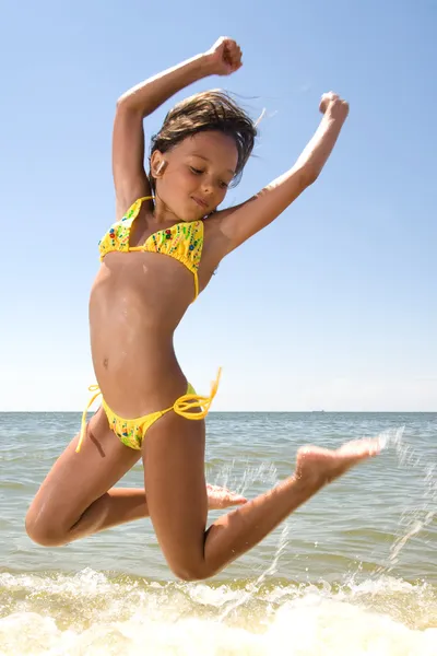 Little girl jumping at the sea — Stock Photo, Image