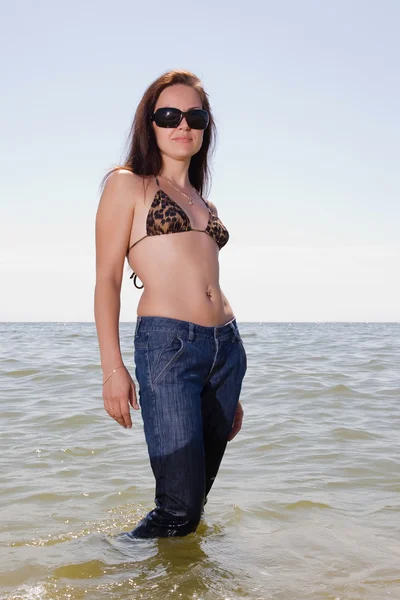 Молодая женщина в джинсах у моря — стоковое фото