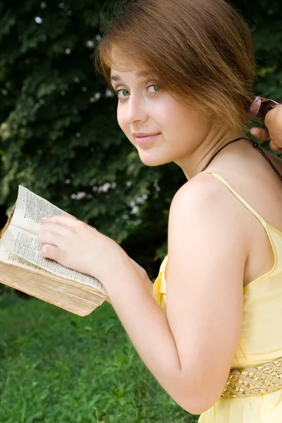 Молода дівчина вивчає книгу на відкритому повітрі — стокове фото