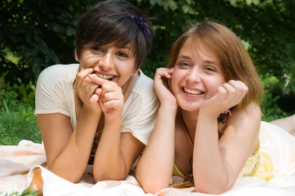 Chicas señalando con el dedo en algo sonriente — Foto de Stock