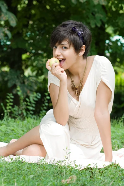 Healthy young girl eating an apple outdoors — Stock Photo, Image
