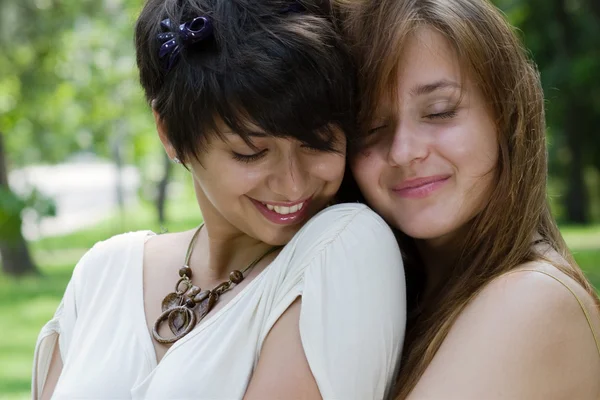Zwei Freundinnen, die sich im Freien umarmen — Stockfoto