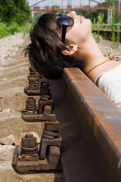 Girl laying on the railroad carelessly — Stock Photo, Image