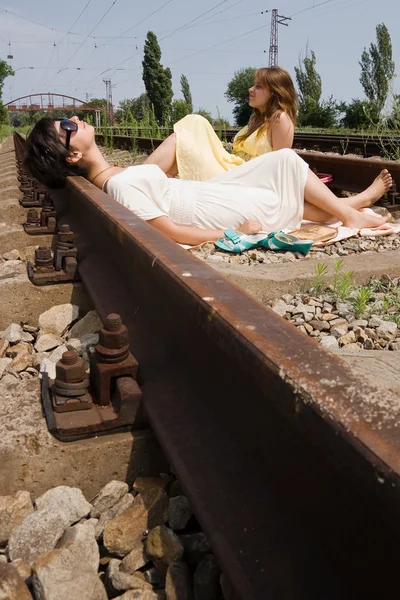 Girls resting on the railroad carelessly — Stock Photo, Image