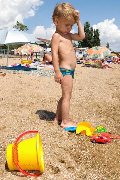Jovem brincando wiht balde e areia — Fotografia de Stock