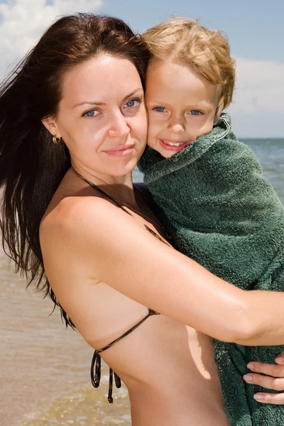 她的小儿子在海滩上的年轻女人 — 图库照片