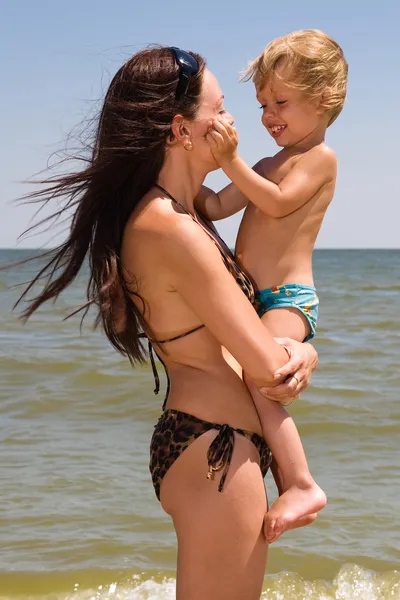 그녀의 작은 아들을 바다에서 노는 젊은 어머니 — 스톡 사진