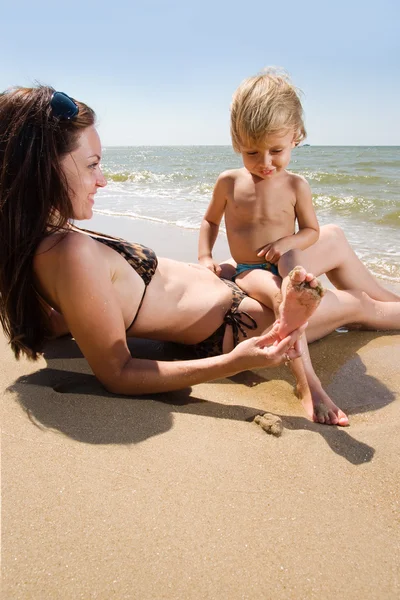 Ung mamma med sin lilla son på stranden — Stockfoto