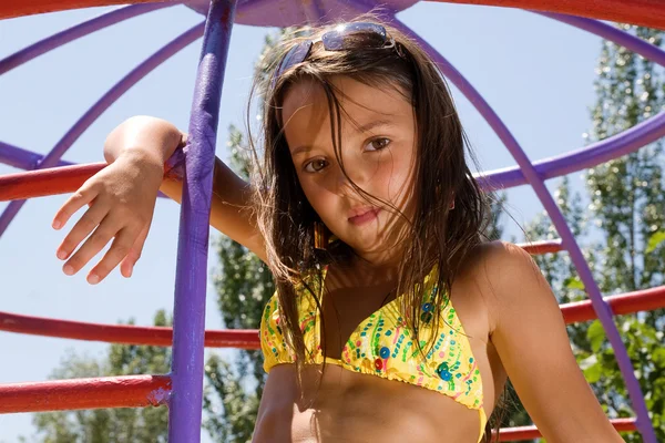 Młoda dziewczyna na placu zabaw w letni dzień — Zdjęcie stockowe
