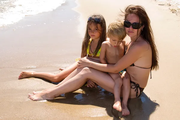 坐在海滩上的年轻家庭 — 图库照片