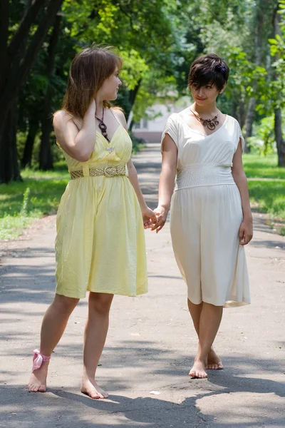Девушки, гуляющие в парке, держатся за руки — стоковое фото
