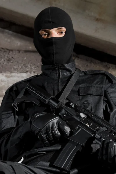 Soldier in black uniform with a gun — Stock Photo, Image