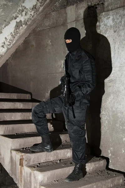 Terrorist i svart maske i trapp – stockfoto