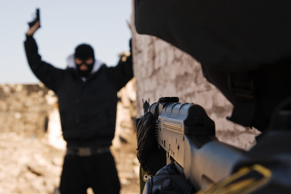 Солдат арестовывает вооруженного преступника
