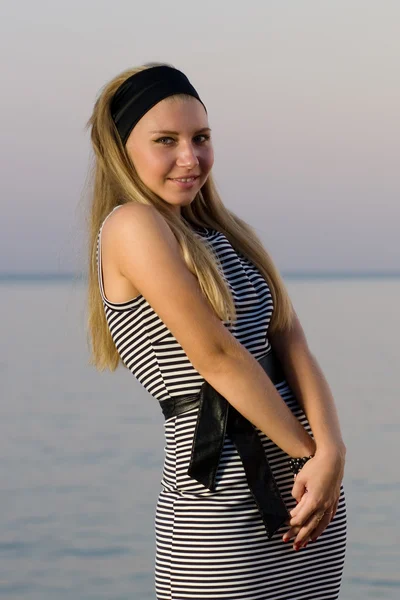 Mosolygó fiatal lány pózol a tengerparton — Stock Fotó
